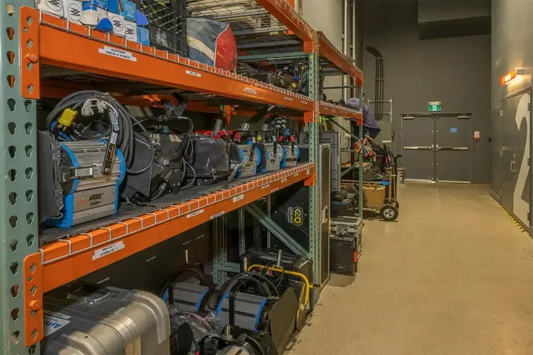 The corridor after, lined with racks of film lights and cable