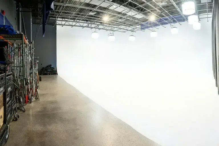 Studio 1 after, the white cyc under the lighting grid with grip stands racked along the wall