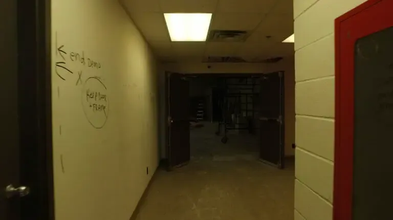The support room before, a dim corridor with notes written on the wall