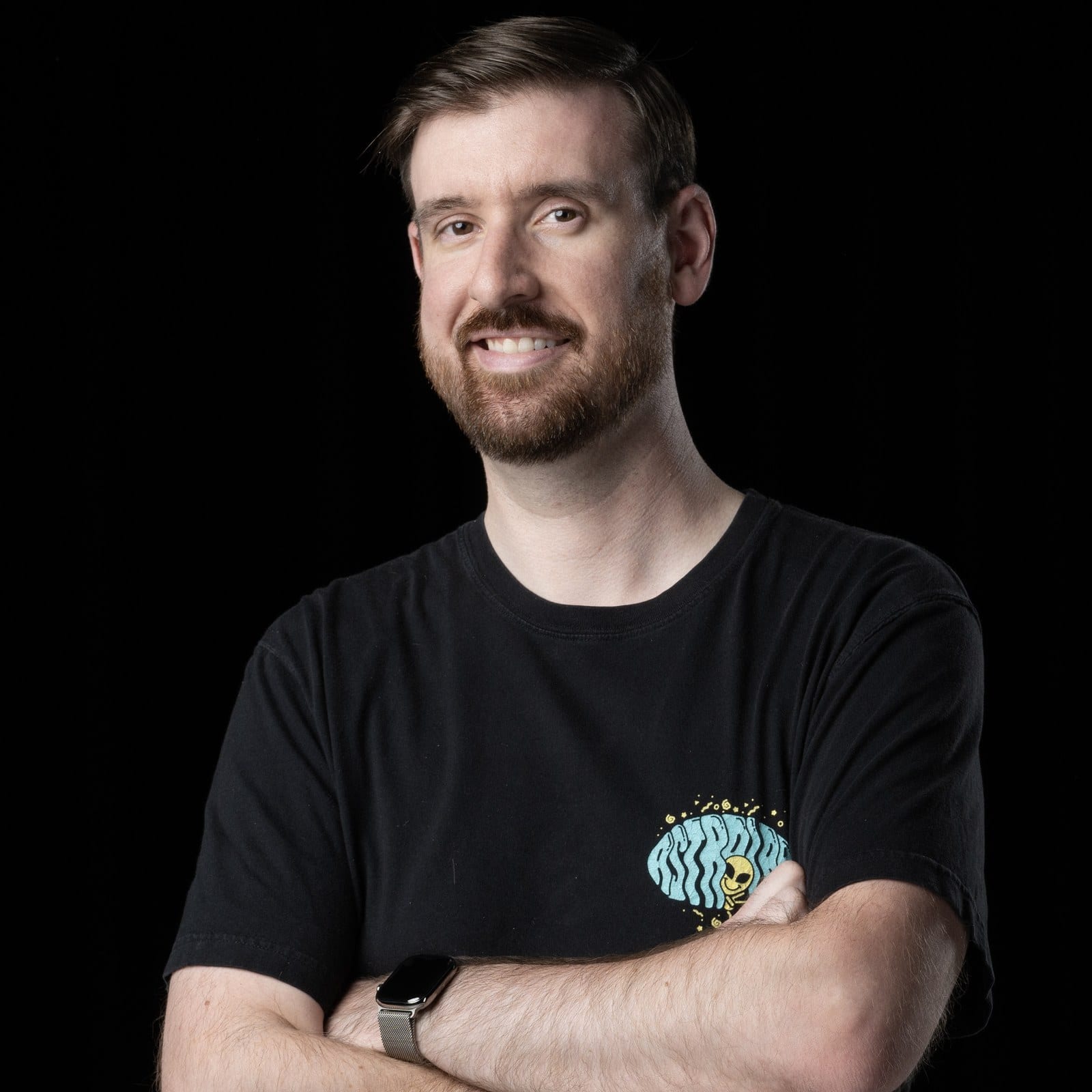 Portrait of Adam Griffiths, arms folded, in an AstroLab T-shirt