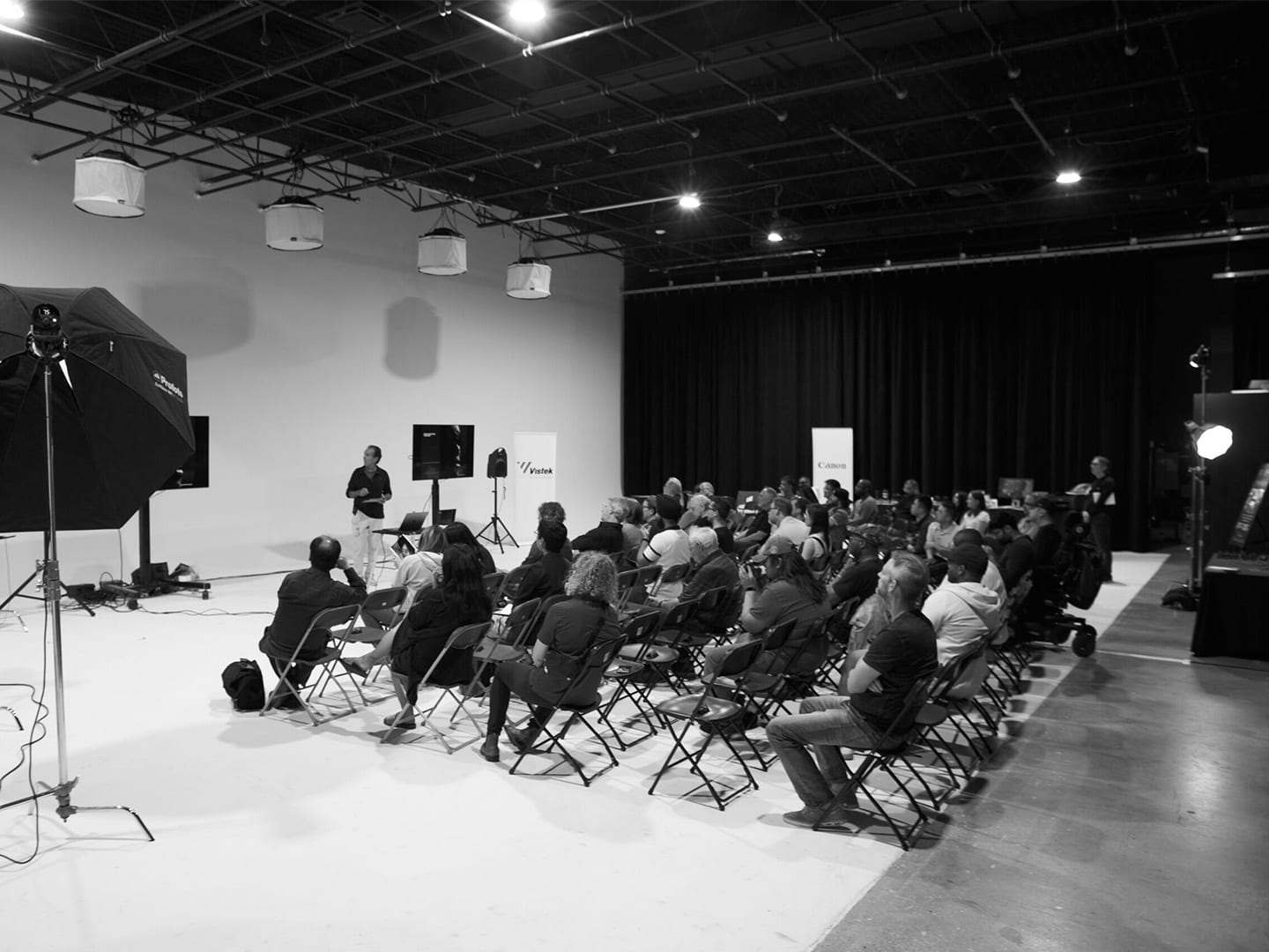 Rows of seated guests filling the cyc for a screening, shot in black and white