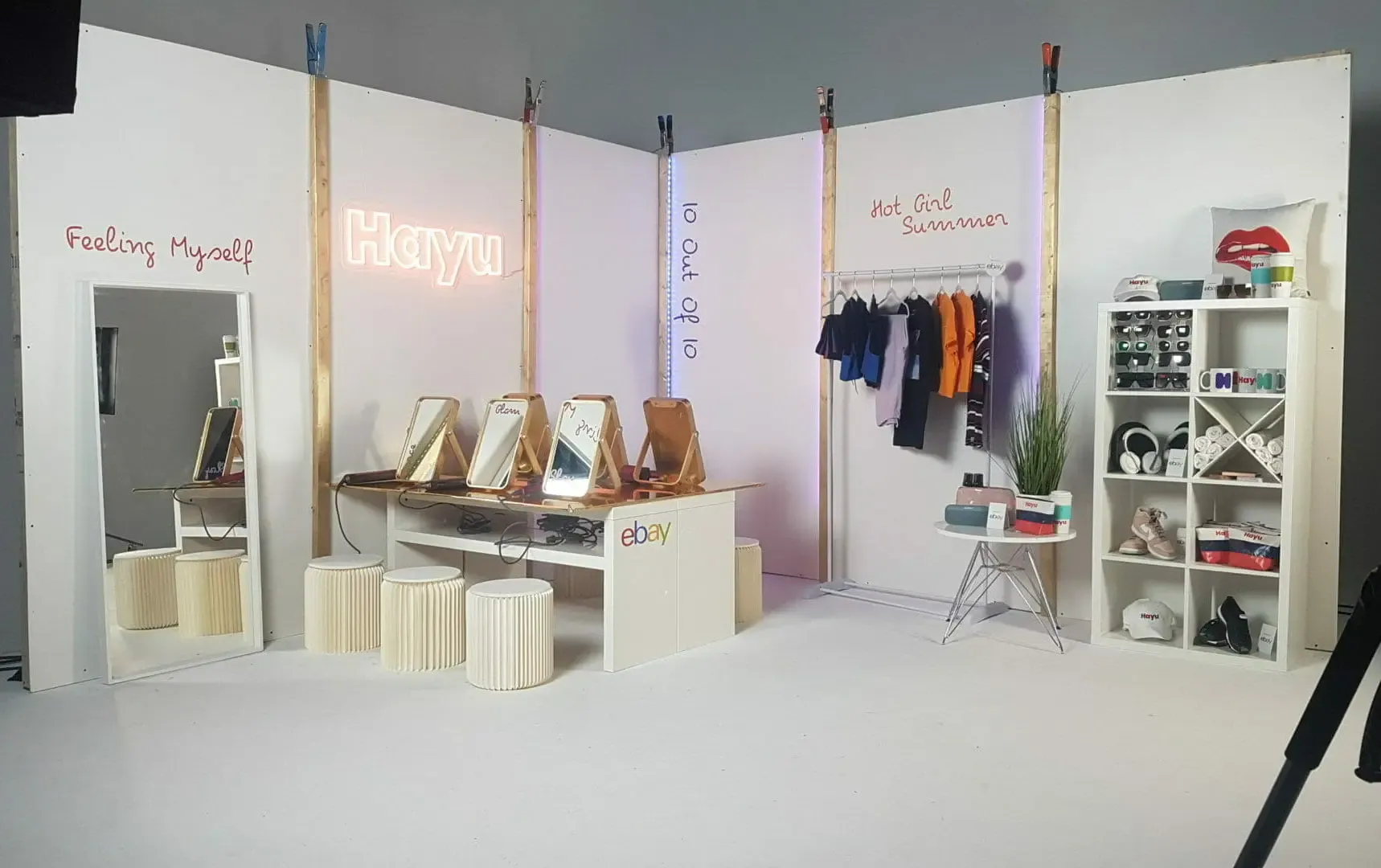 An influencer set built on the cyc, with mirrors, a clothing rail and a neon sign