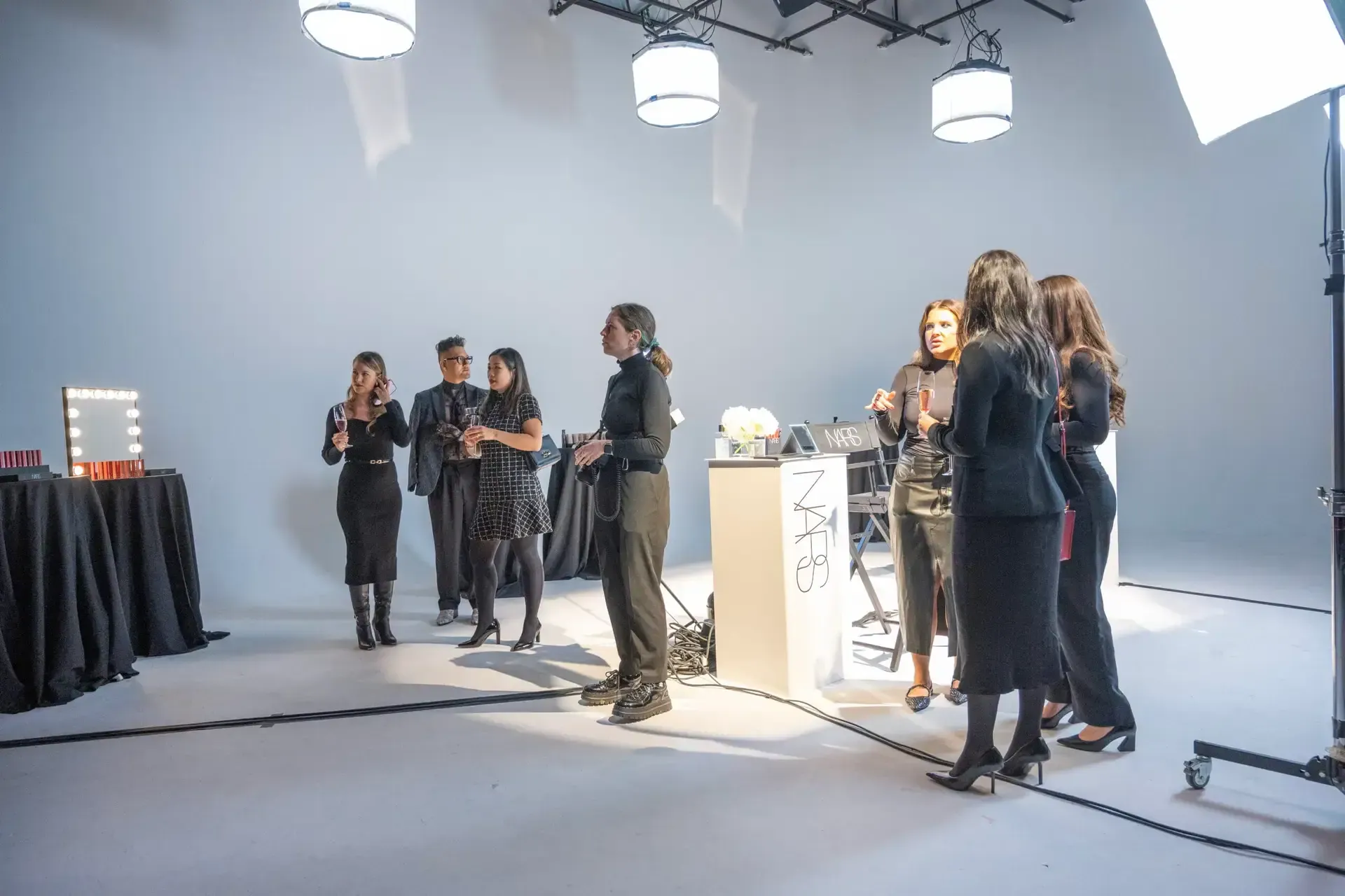 Guests at the same activation, standing on the lit white cyc