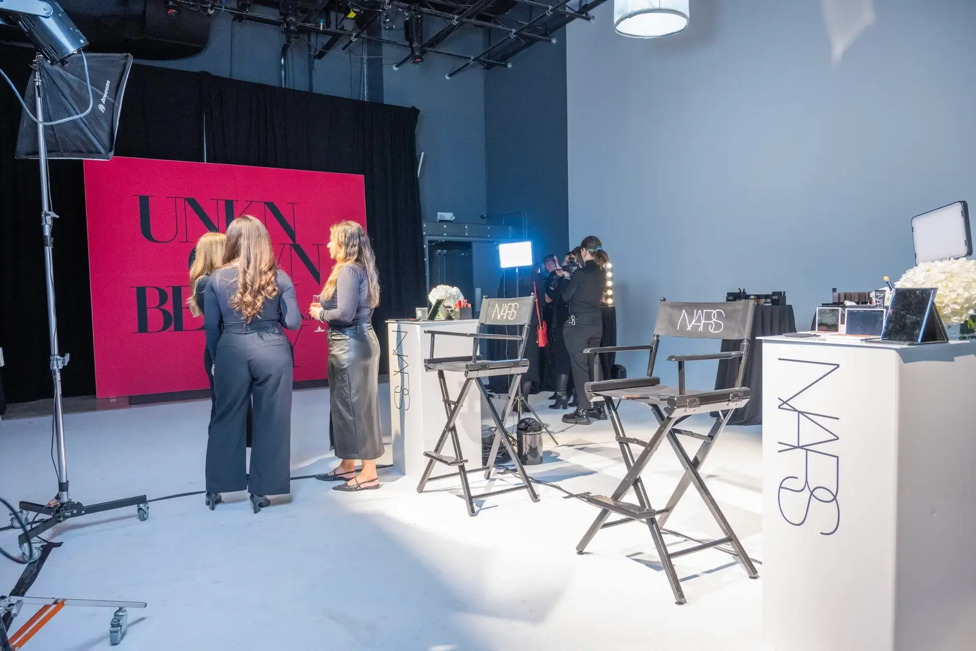 A beauty brand activation built on the stage, with branded directors chairs and a photo wall