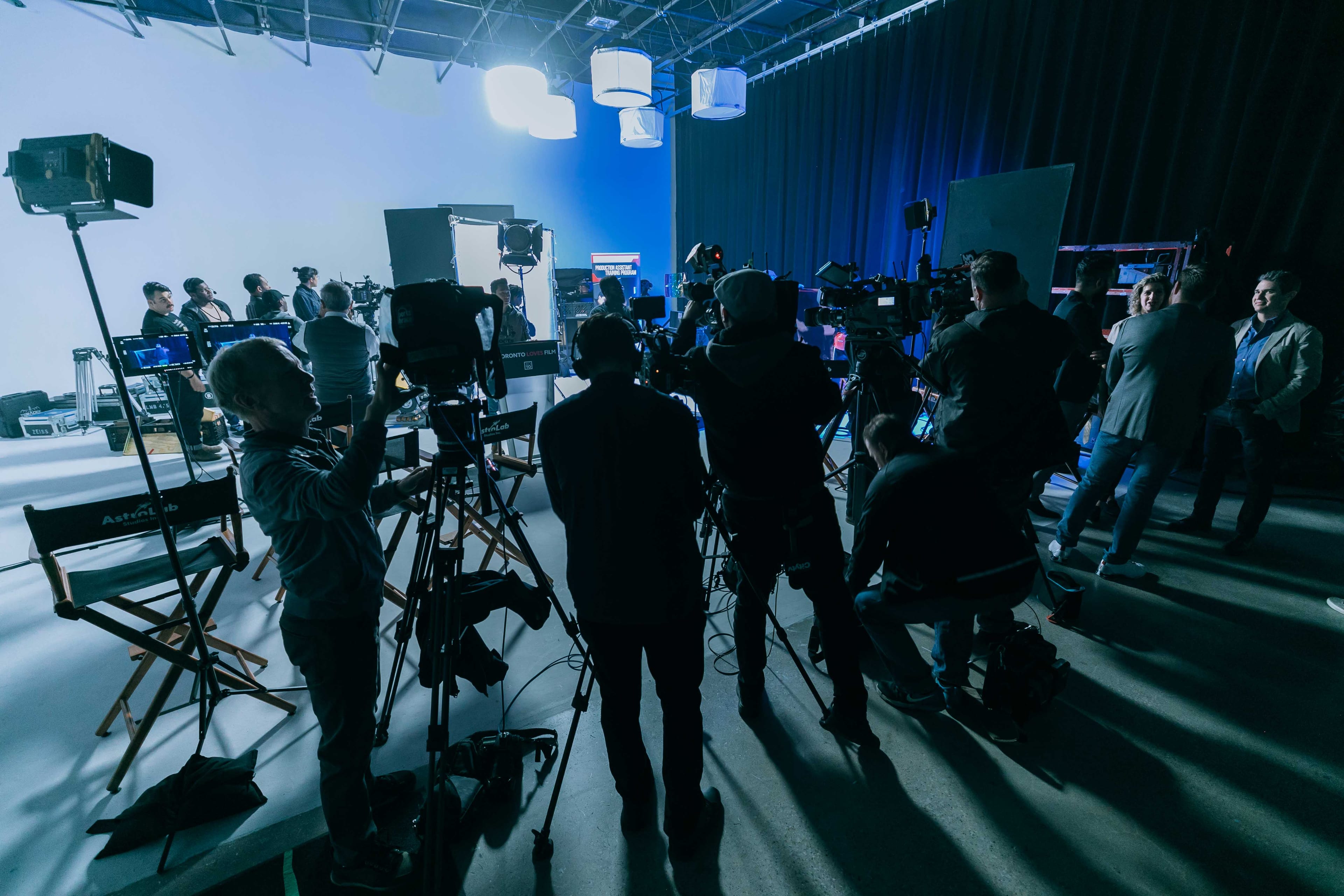 Press cameras lined up on tripods for an announcement on the stage
