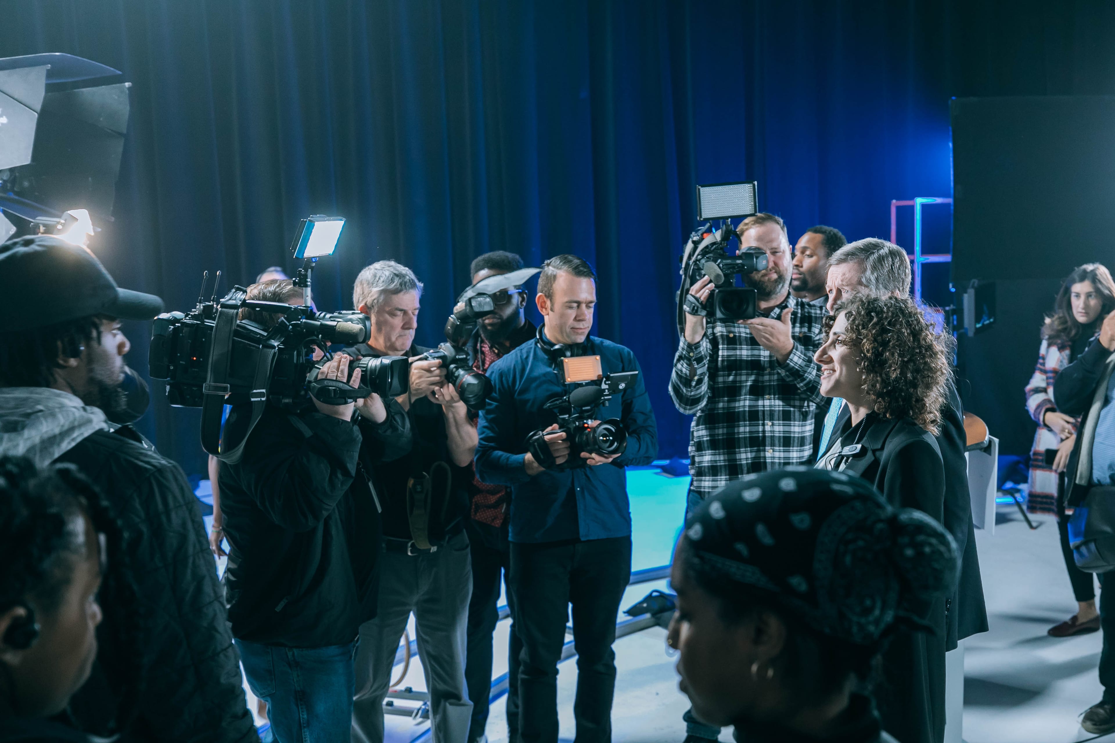 Camera operators surrounding the speakers after the announcement