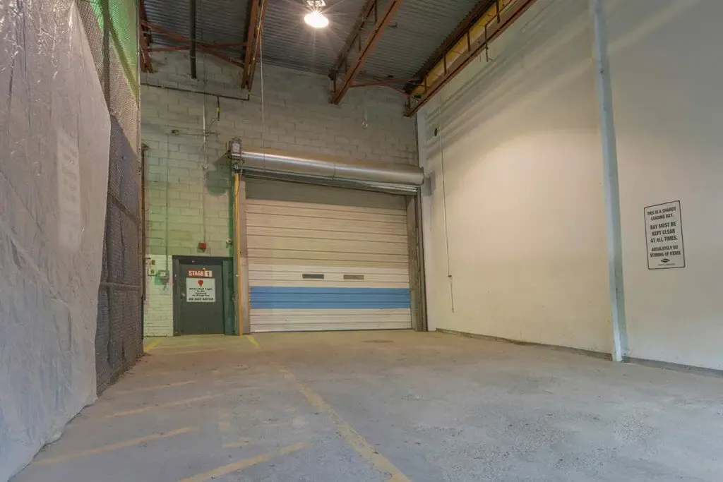 The loading bay: a concrete floor, a roll-up door and a posted sign asking that the bay be kept clear