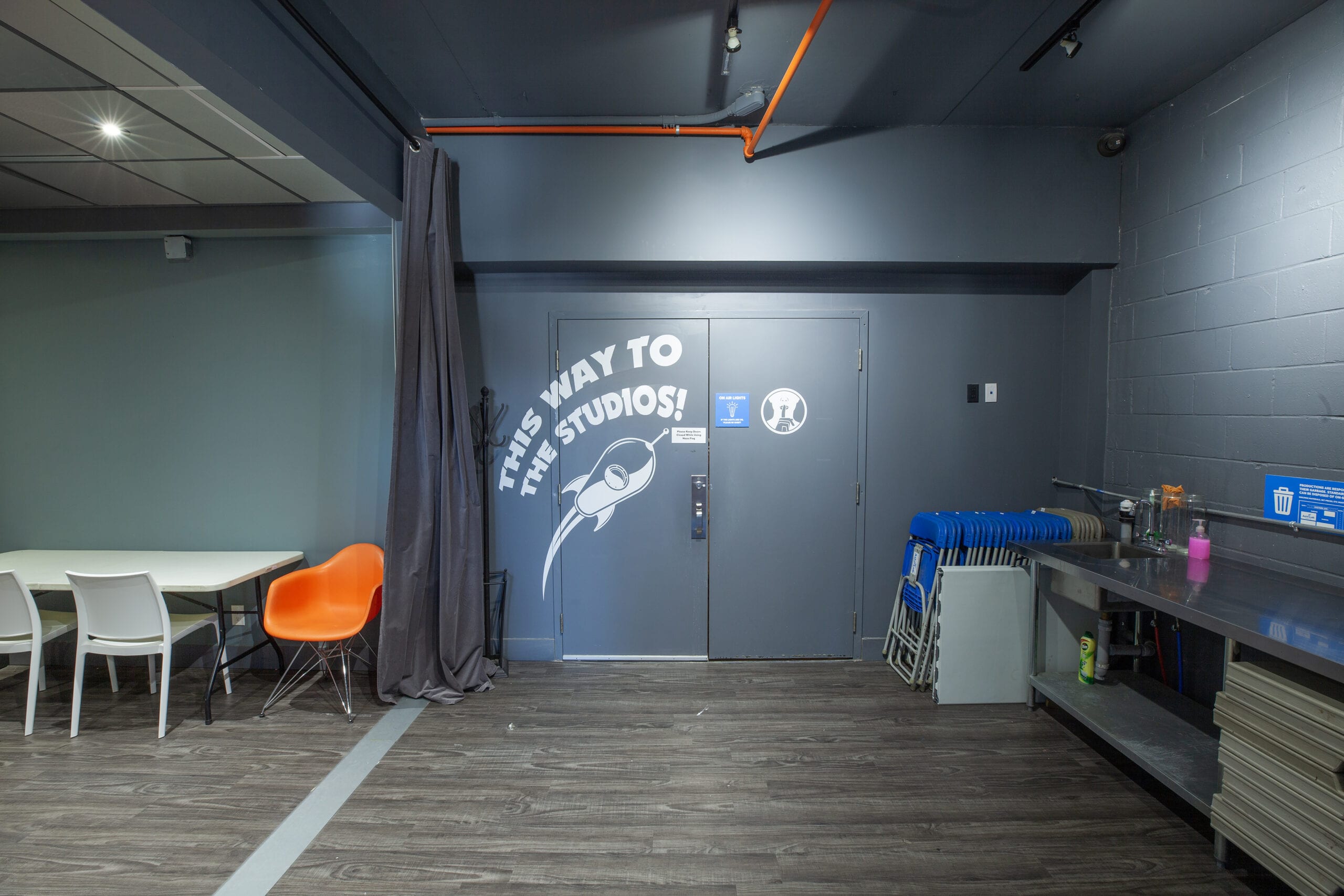 The studio doors seen from the multi-purpose room, painted with a rocket and the words this way to the studios
