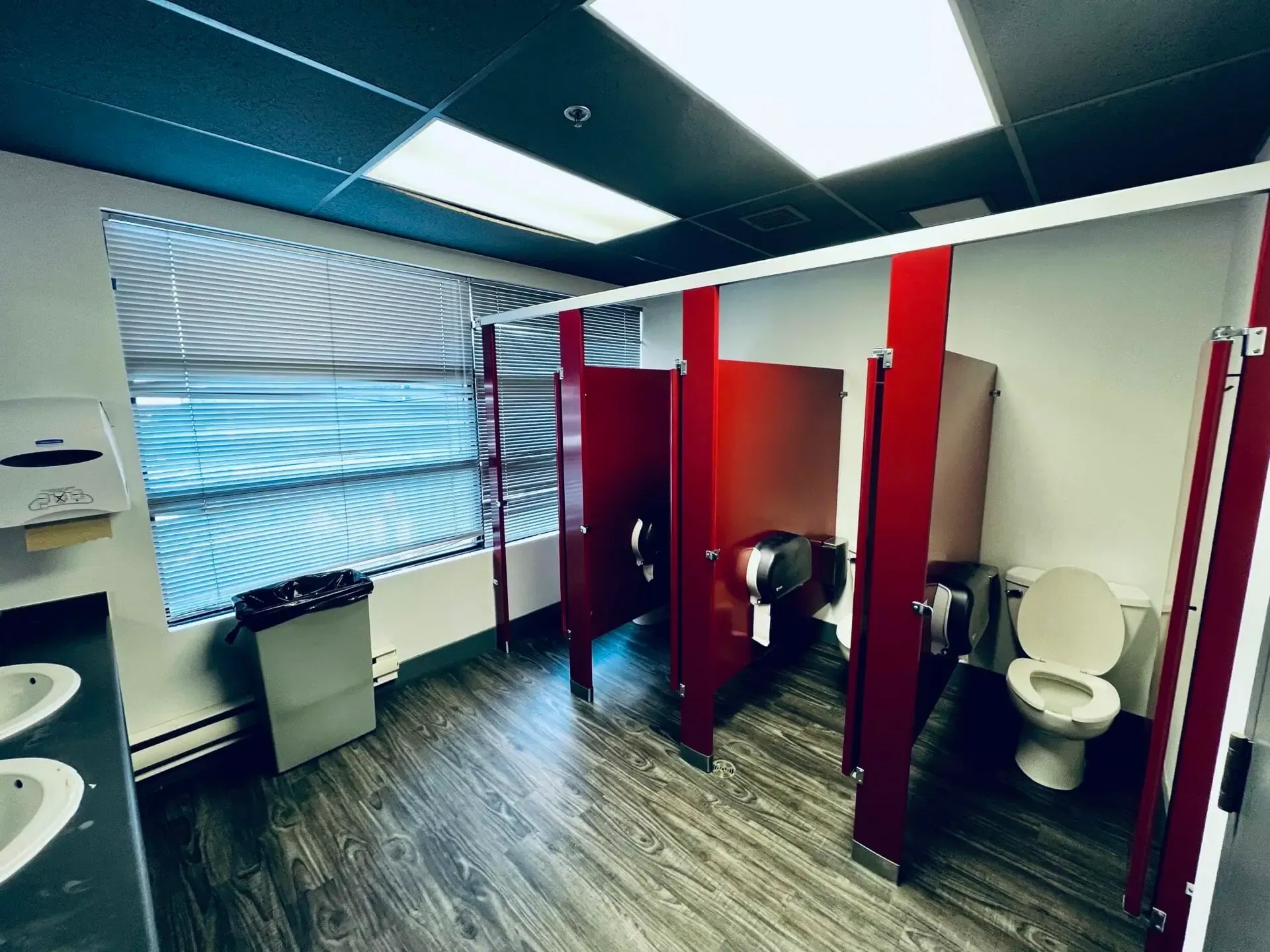 One of the two restrooms, a row of red stalls beside a window